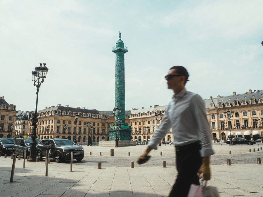 Silhouette masculine traversant la Place Vendôme à Paris, architecture parisienne et atmosphère mode